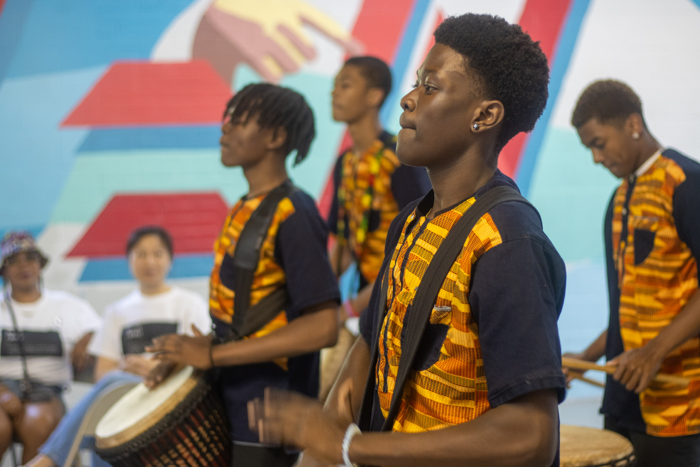 Youth playing jimbe drums